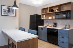 uma cozinha com um lavatório e um frigorífico preto em Candlewood Suites Elkhart, an IHG Hotel em Elkhart