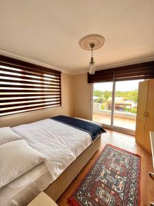 a bedroom with a bed and a large window at VİLLA DALAMAN in Dalaman