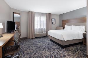 um quarto de hotel com uma cama, uma secretária e uma televisão em Candlewood Suites Elkhart, an IHG Hotel em Elkhart