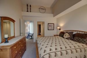 1 dormitorio con cama, tocador y espejo en Pines 2129, en Keystone
