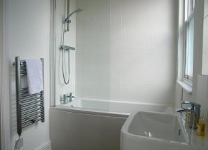 チェルムスフォードにあるStunning 2-Bed Apartment in Chelmsfordのバスルーム(バスタブ、シンク、シャワー付)