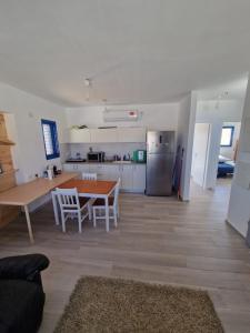 a living room with a table and a kitchen at Yvonne's Hikers Base Sde Boker in Midreshet Ben Gurion
