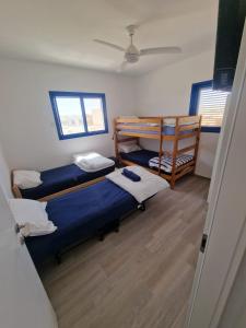 a room with three bunk beds and a ceiling at Yvonne's Hikers Base Sde Boker in Midreshet Ben Gurion
