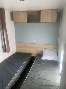 a small room with two beds and a cabinet at Vacance à la Carabasse in Vias