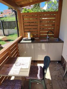 an outdoor kitchen with a sink and a table and chairs at Guesthouse Suzy in Pula