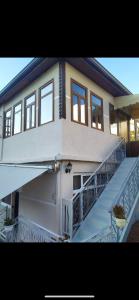 a white house with a balcony and a staircase at B&BSheshalliu in Berat