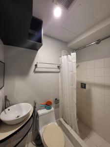 y baño con aseo y lavamanos. en Legaspi Loft Suite, en Manila