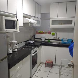 cocina con armarios blancos y fogones en DEPARTAMENTO BREÑA POR Hospital LOAYZA, en Lima
