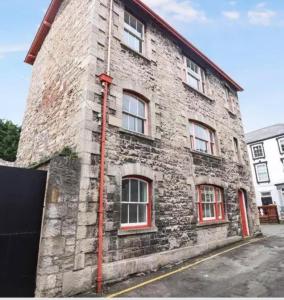 a brick building with red windows on a street at Large heritage-House close Snowdonia & Llandudno in Denbigh