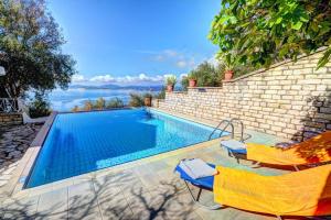 a swimming pool with two lounge chairs next to it at Rolling Stolis Home in Katávolos