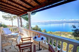 a balcony with a table and chairs and a view of the water at Rolling Stolis Home in Katávolos