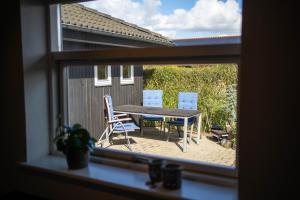 una ventana con vistas a una mesa y sillas en Bjerrebo idyl - Romalt Bakker, en Randers