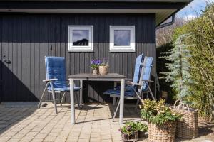 a patio with two chairs and a table and two windows at Bjerrebo idyl - Romalt Bakker in Randers