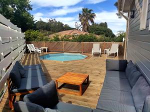 patio z basenem, krzesłami i stołem w obiekcie Chalet 60m² entièrement climatisé w mieście Gassin