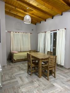 a dining room with a table and chairs and a couch at Cabañas del Arroyo Villa Ventana in Villa Ventana