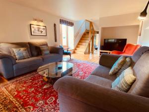 a living room with two couches and a coffee table at Crofts Mill in Ballater