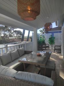 a patio with a couch and a table on a porch at Chalet 60m² entièrement climatisé in Gassin