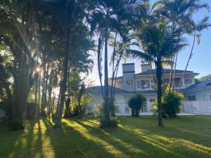 uma casa com palmeiras em frente em Pousada Vivera em Jaraguá do Sul