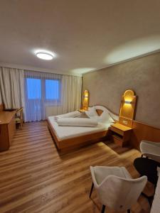 a hotel room with a bed and a desk and chairs at Hotel Garni Romantica in Jerzens