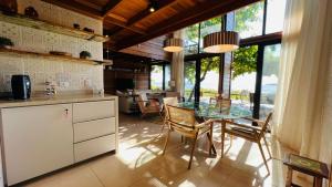 a kitchen and dining room with a glass table and chairs at Ilha do Mel Lodges in Ilha do Mel