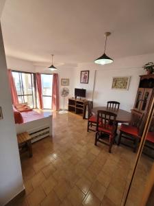 a living room with a table and chairs and a desk at Panoramico in Santa Teresita +6 photos