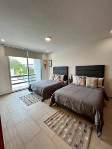 聖路易斯波托西的住宿－Lujoso Departamento Lomas 3，一间卧室设有两张床和大窗户