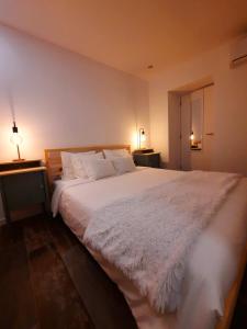 ein Schlafzimmer mit einem großen weißen Bett mit zwei Lampen in der Unterkunft Casa A Júlia In Faro's Heart in Faro