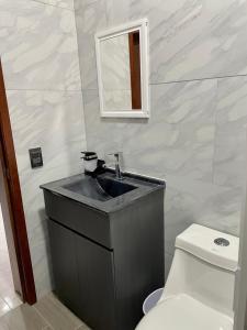 W łazience znajduje się umywalka, toaleta i lustro. w obiekcie Departamentos Madera w mieście Tequila