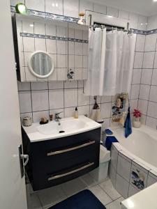 a bathroom with a sink and a tub and a mirror at Chambre chez l’habitant chez Nadine in Cagnes-sur-Mer