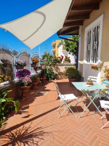 un patio con tavolo, sedie e fiori di B&B Nonna Gianna a Pompei