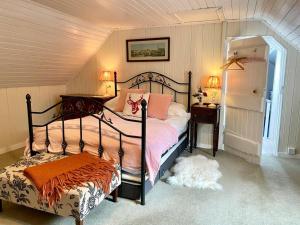 ein Schlafzimmer mit einem Bett, einem Tisch und zwei Lampen in der Unterkunft Traditional farm cottage with woodburner by stream in Cladich
