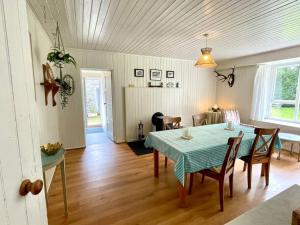 ein Esszimmer mit einem Tisch und Stühlen in einem Zimmer in der Unterkunft Traditional farm cottage with woodburner by stream in Cladich