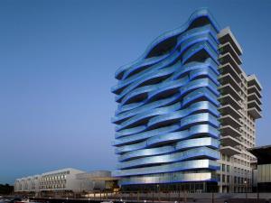 a tall blue building with a curved facade at Troia Design Hotel in Troia