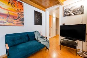 sala de estar con sofá azul y TV de pantalla plana en Suite Hidalgo De Menezes, en Bari