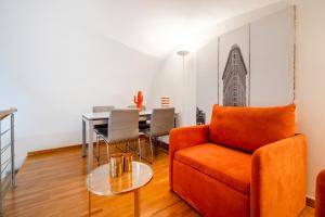 una sala de estar con una silla naranja y una mesa en Suite Hidalgo De Menezes, en Bari