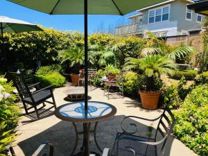 a table and chairs with an umbrella on a patio at Tropical Retreat Close to Beach in Grover Beach