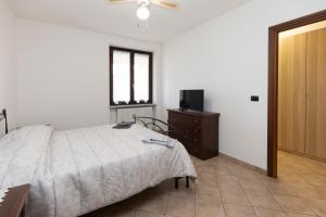 1 dormitorio con 1 cama, vestidor y TV en Villa Anna, en Moncalieri