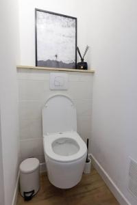 La salle de bains est pourvue de toilettes blanches et d'une fenêtre. dans l'établissement • Au Cosy Dôme. •, à Royat