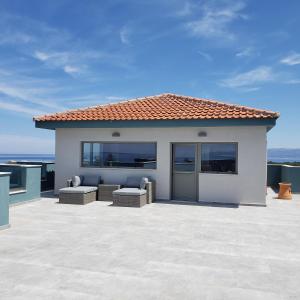 a house with a patio with a view of the ocean at Evalia Apartments in Hersonissos