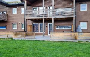a house with a wooden deck in front of it at Vacation apartment in Hornnes