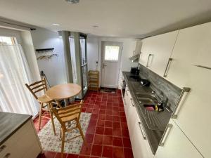 a small kitchen with a table and a sink at Fünf Seen Apartments in Weilheim in Oberbayern