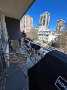 a balcony with two chairs and a table and buildings at Ocean view in Vancouver