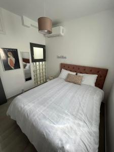 um quarto com uma cama grande e lençóis brancos em Tiffany's apartments -2' walk from Metro em Atenas