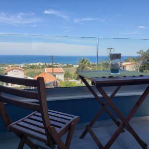 ヘルソニソスにあるEvalia Apartmentsのテーブルと椅子、海の景色を望むバルコニー
