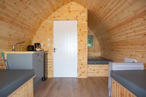 uma cozinha com uma porta branca numa casa de madeira em Glamping Pod 2 Magical Craigengillan Estate em Dalmellington