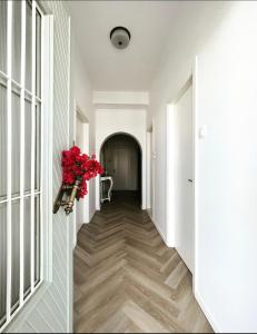 a hallway with a vase of red flowers on the wall at Kamelia Hotel in Spetses