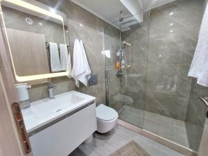 een badkamer met een douche, een wastafel en een toilet bij MAXIM APARTMENT in Heraklion