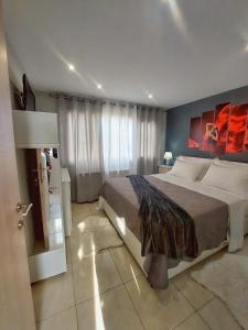 sypialnia z dużym łóżkiem i dużym oknem w obiekcie MAXIM APARTMENT w Heraklionie