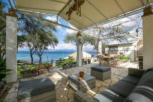 an outdoor patio with a view of the ocean at Sailors Luxury Cottage in Agia Pelagia Chlomou