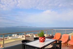 un tavolo e sedie su un balcone con vista sull'oceano di MAXIM APARTMENT a Heraklion